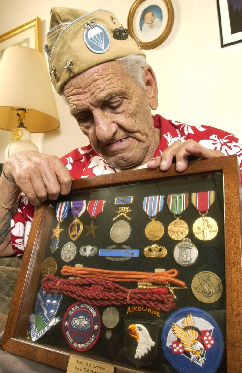Bill Guarnere in 2004 holding a shadow box of his Silver Star, Bronze Stars, Purple Hearts and 506th PIR patches